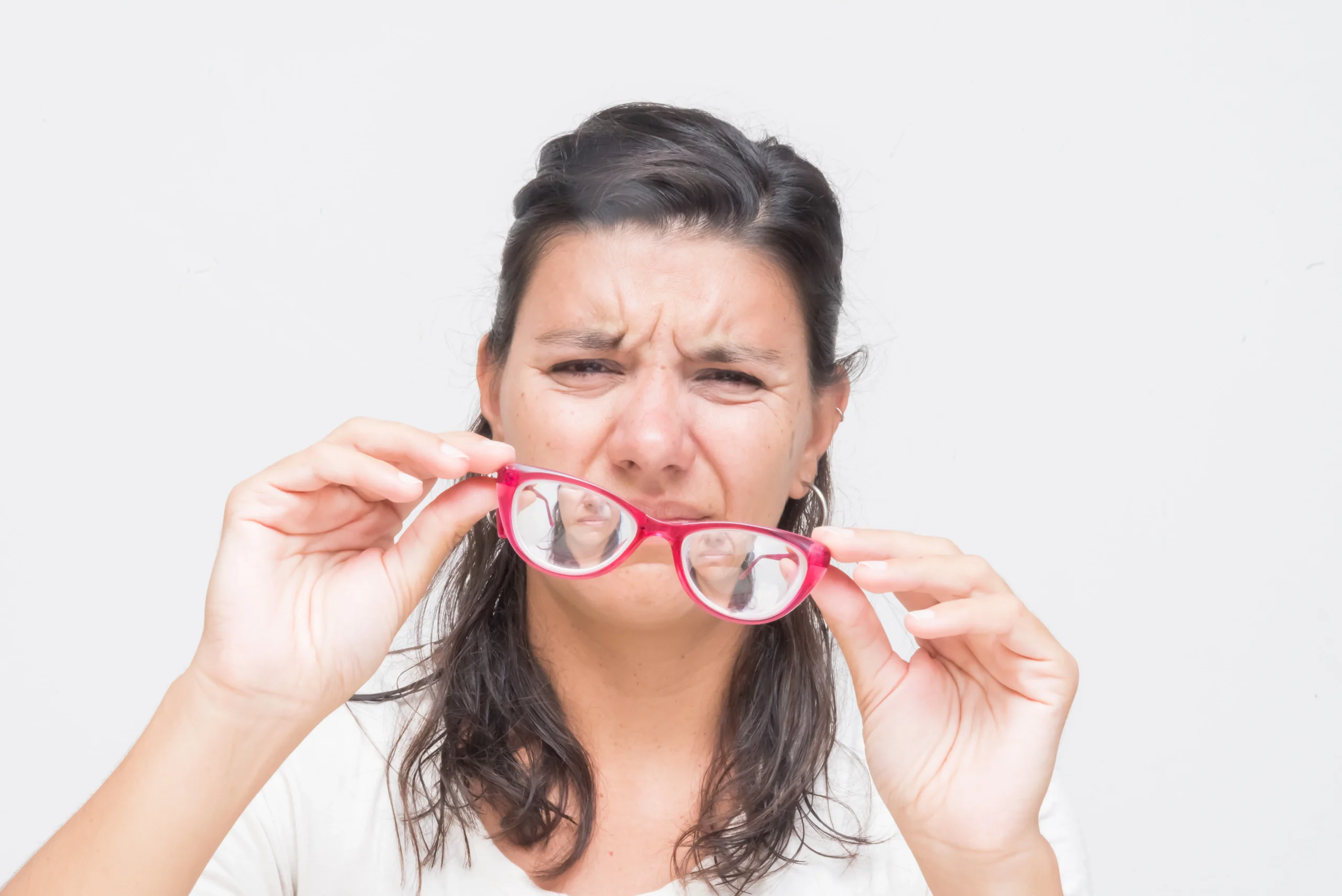unzufriedene Frau mit Brille bei starker Fehlsichtigkeit